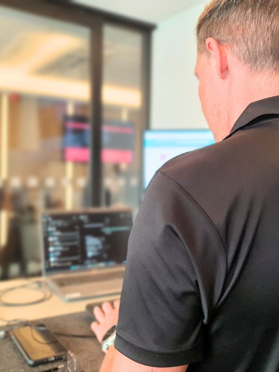 IT support specialist from BSG working at a desk with multiple monitors in a modern office